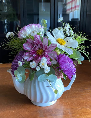 Garden Part Flowers.  This cute arrangement consists of Purple Asters, Pink and white cosmos, Marshmallow Yarrow, Cosmo foliage and Eucalyptus.  Beautifully arranged in a upcycled teapot.