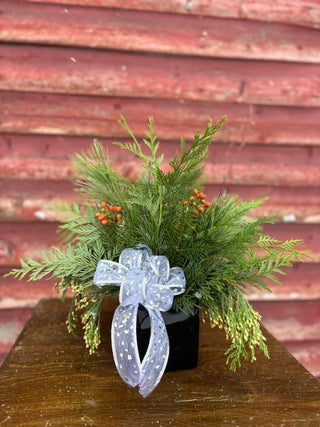 A beautiful ceramic pot filled with fresh BC greens, including cedar, pine, fir, and rose hips, designed as a sustainable holiday centrepiece.