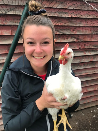 Cute girl holding a white chicken.  We raise boilers for meat.