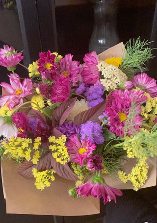 Summer mixed cut flower bouquet consisting of yellow statice, purple cosmos, ageratum, yarrow and cosmo greens.